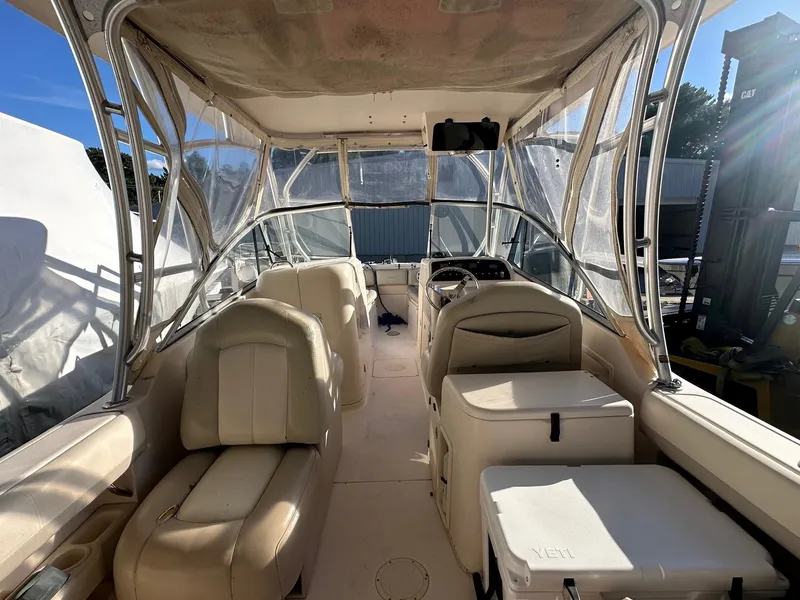 Slide: The Image of 2011 Grady-White 275 boat interior with seating and helm, featuring clear canopy. - 3