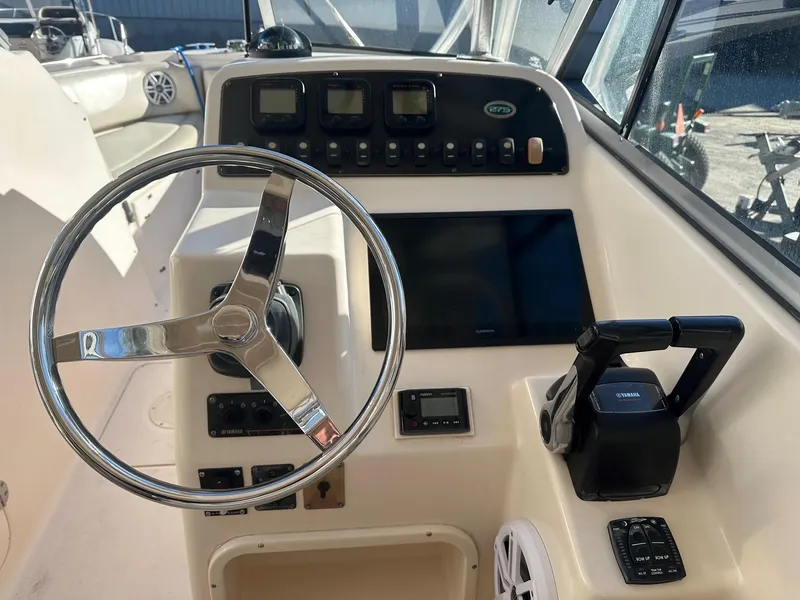 Slide: The Image of 2011 Grady-White 275 boat dashboard with steering wheel and control panel. - 6