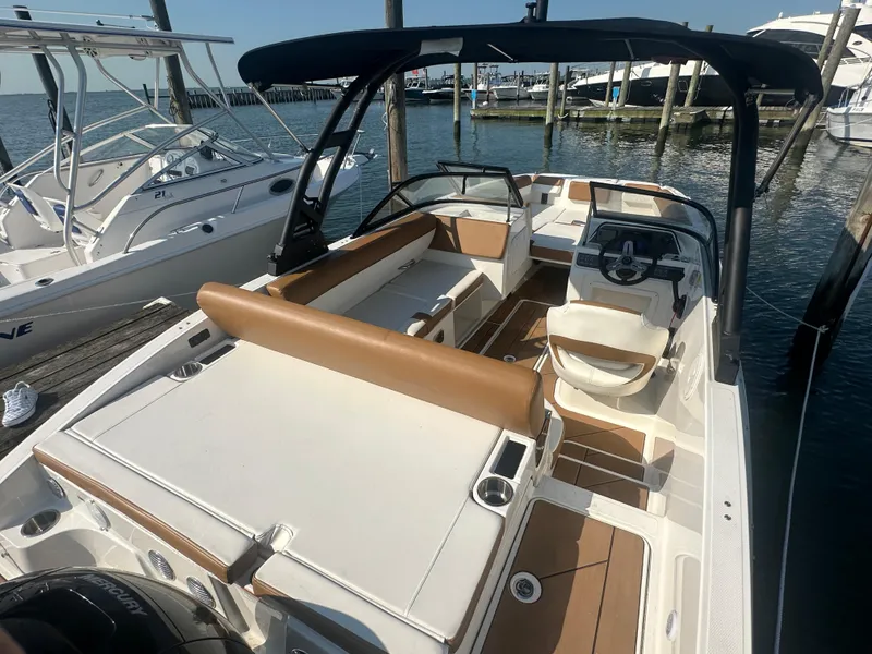 Slide: The Image of 2022 Bayliner DX 2000 boat with tan seating, docked at marina. - 11