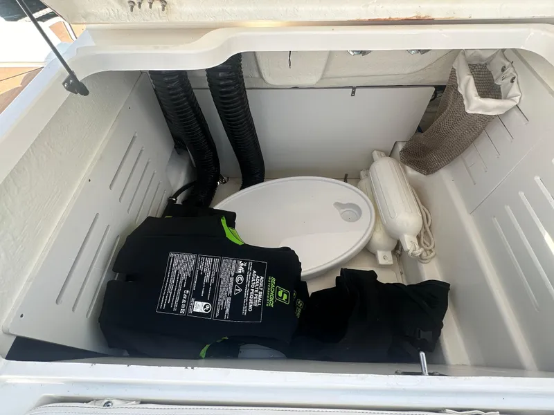 Slide: The Image of Storage compartment in 2022 Bayliner DX 2000 boat with life jacket and fender. - 14