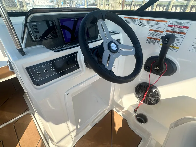Slide: The Image of 2022 Bayliner DX 2000 boat dashboard with steering wheel and controls. - 4