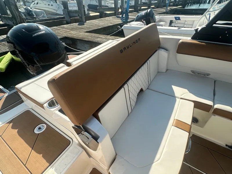 Slide: The Image of 2022 Bayliner DX 2000 boat interior with tan and white seating at dock. - 9