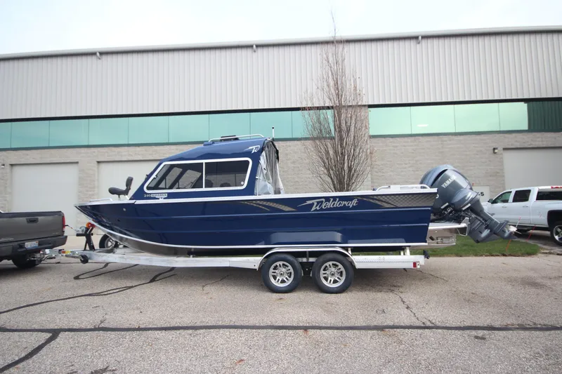 The Image of 2025 Weldcraft 240 Maverick DV boat on trailer, parked outside industrial building. - 0