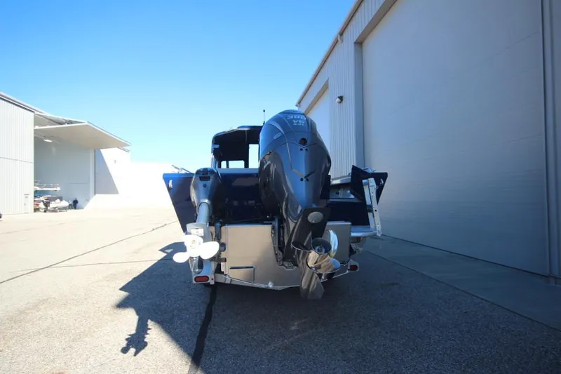 Slide: The Image of 2025 Weldcraft 240 Maverick DV boat with outboard motor, parked near a building. - 10