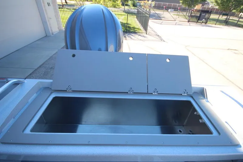 Slide: The Image of 2025 Weldcraft 240 Maverick DV boat storage compartment with open lid, outdoor setting. - 17