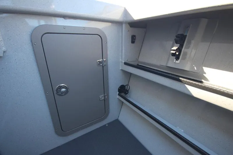 Slide: The Image of 2025 Weldcraft 240 Maverick DV interior storage compartment with secure door and shelving. - 19