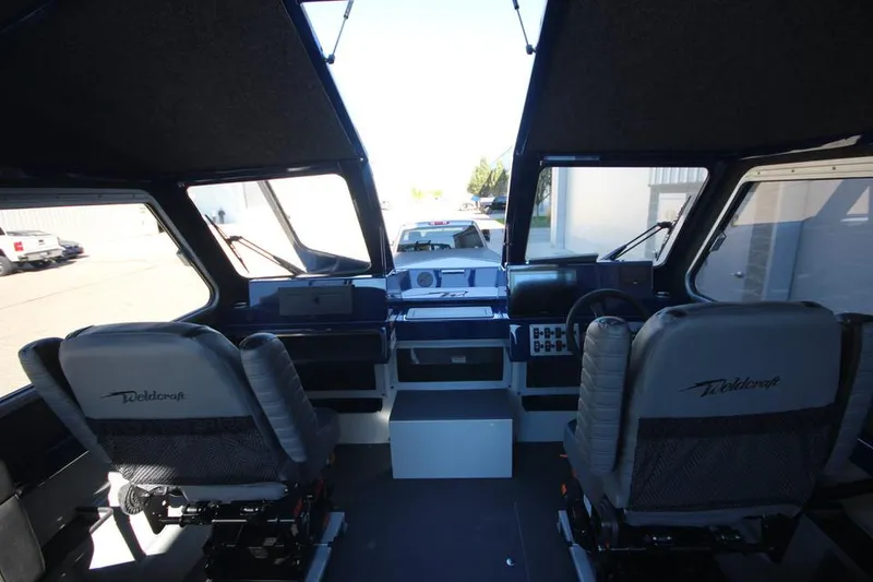 Slide: The Image of 2025 Weldcraft 240 Maverick DV boat interior with dual seats and dashboard view. - 33