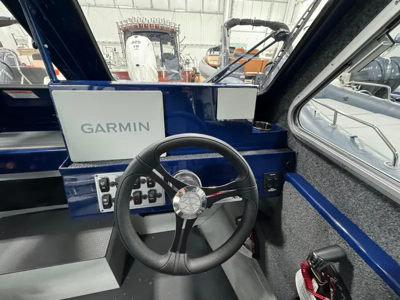 Slide: The Image of 2025 Weldcraft 240 Maverick DV boat cockpit with Garmin navigation system and steering wheel. - 44