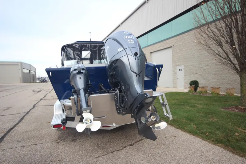 Slide: The Image of 2025 Weldcraft 240 Maverick DV boat with dual outboard motors, parked outdoors. - 5