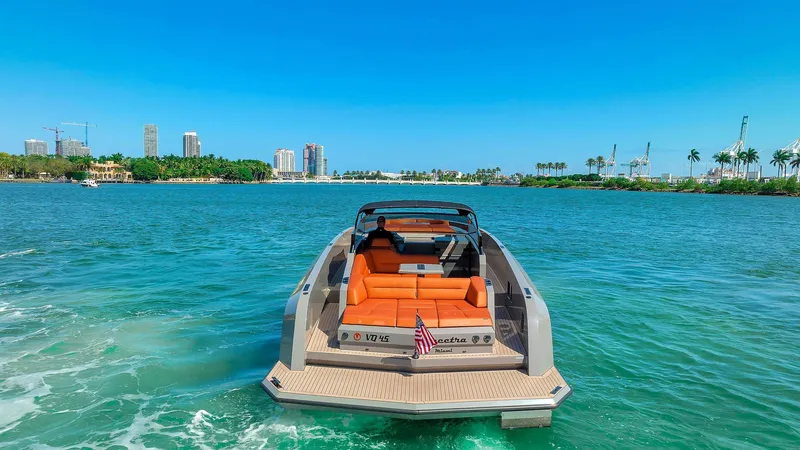 Slide: The Image of 2021 Vanquish Yachts VQ 45 on water, luxury yacht with orange seating, city skyline background. - 15