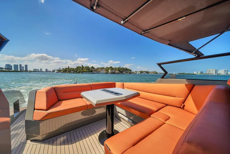 Slide: The Image of Luxurious 2021 Vanquish Yachts VQ 45 with orange seating, ocean view, and city skyline. - 24