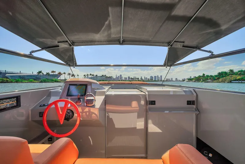 Slide: The Image of Interior view of 2021 Vanquish Yachts VQ 45 with red steering wheel and city skyline. - 32