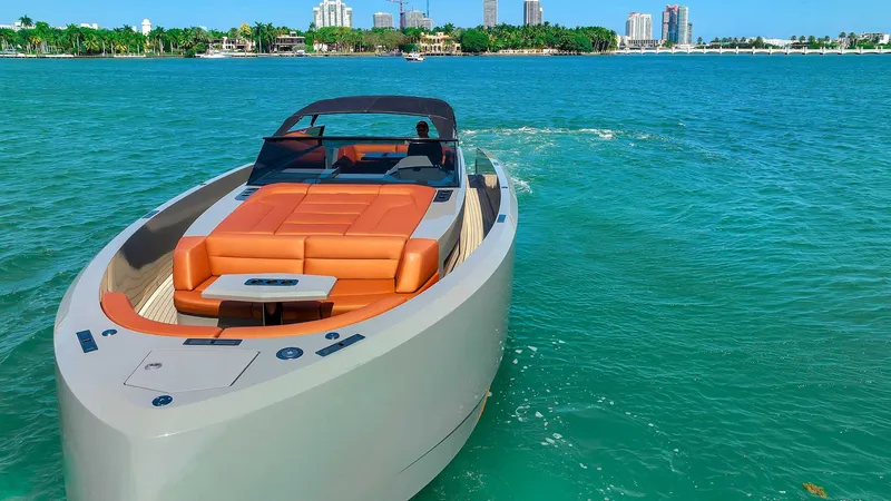 Slide: The Image of 2021 Vanquish Yachts VQ 45 cruising on turquoise waters near a city skyline. - 8