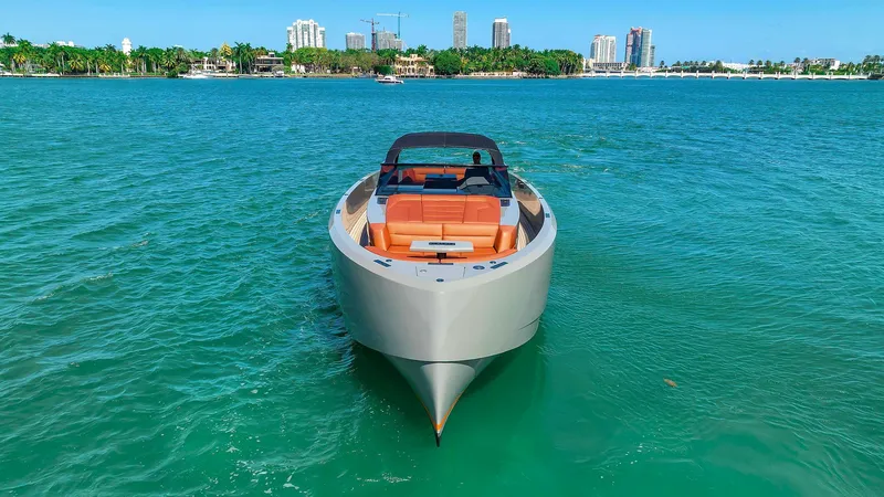 Slide: The Image of Vanquish Yachts VQ 45, 2021 model, cruising on turquoise waters with city skyline backdrop. - 11