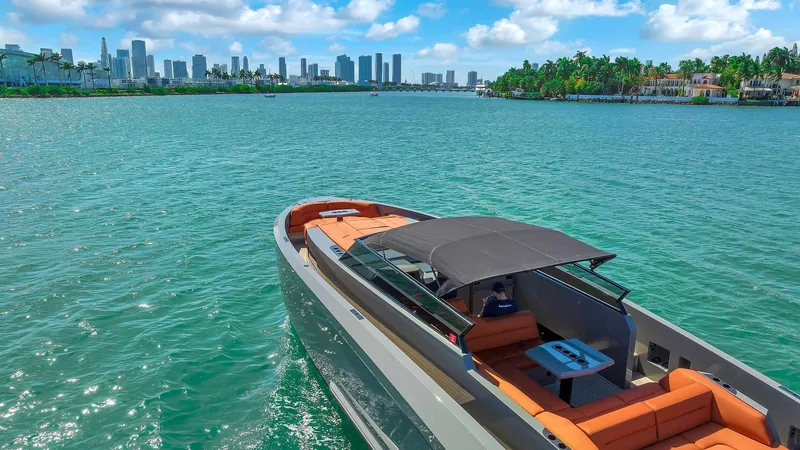 Slide: The Image of Vanquish Yachts VQ 45, 2021 model, cruising in a scenic coastal cityscape. - 6