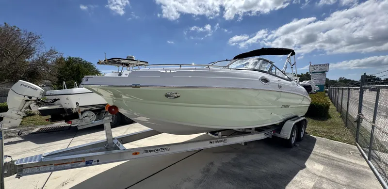 The Image of 2025 Stingray 231DC boat on trailer under blue sky. - 0