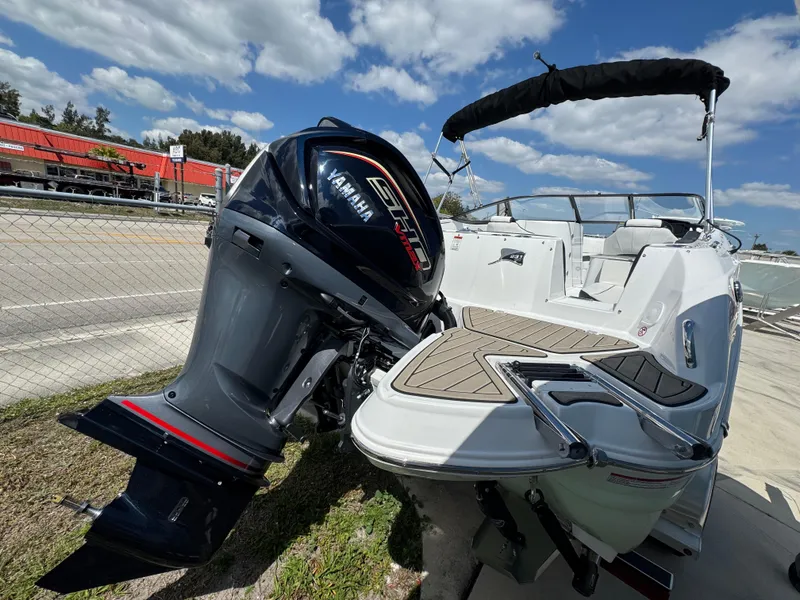 Slide: The Image of 2025 Stingray 231DC boat with Yamaha outboard motor, docked under a clear blue sky. - 1