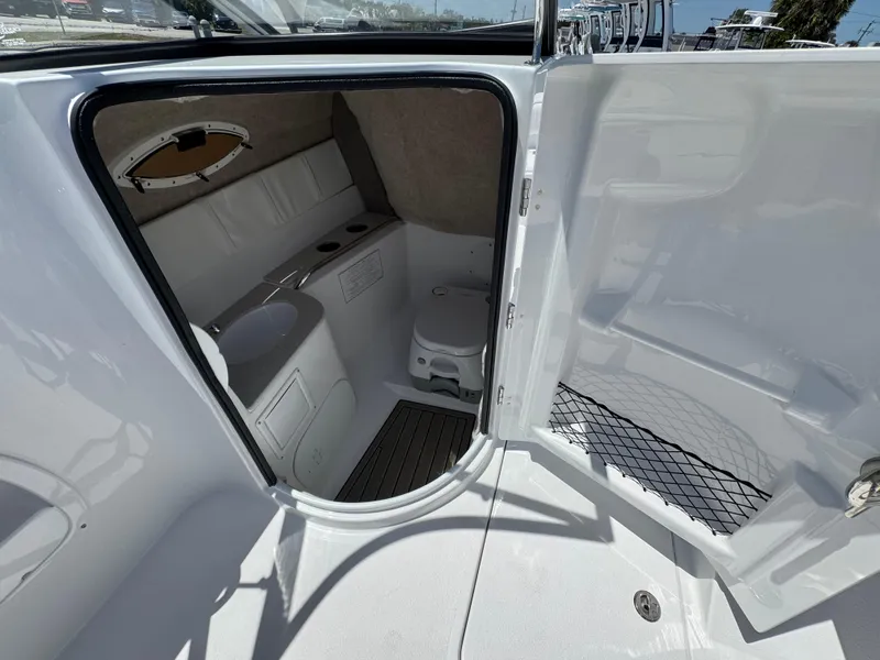 Slide: The Image of 2025 Stingray 231DC boat interior with compact bathroom and storage space. - 12