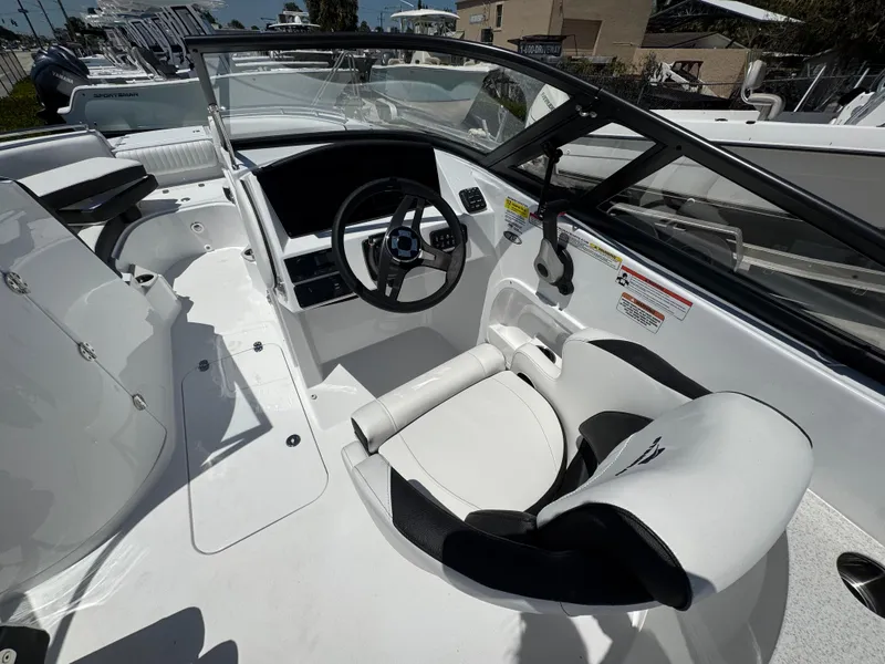 Slide: The Image of 2025 Stingray 231DC boat interior with sleek white seating and modern steering console. - 17