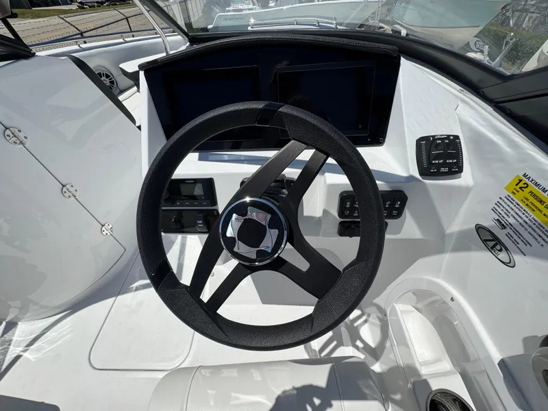 Slide: The Image of Steering wheel and dashboard of 2025 Stingray 231DC boat, featuring modern controls and displays. - 18