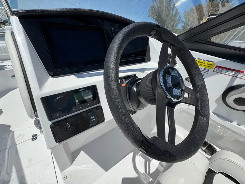 Slide: The Image of 2025 Stingray 231DC boat dashboard with steering wheel and control panel. - 19