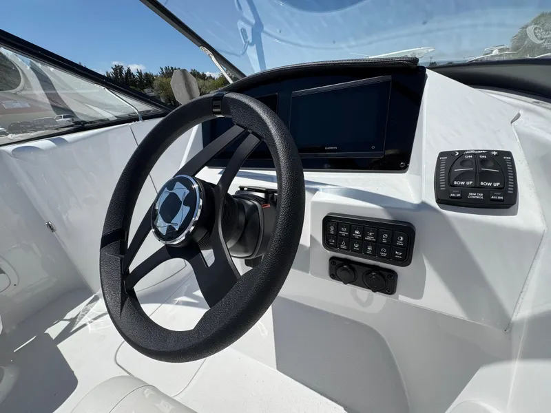 Slide: The Image of 2025 Stingray 231DC boat dashboard with steering wheel and control panel. - 20