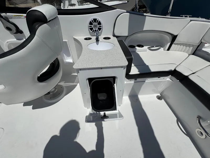 Slide: The Image of 2025 Stingray 231DC boat interior with seating, sink, and storage compartment. - 21