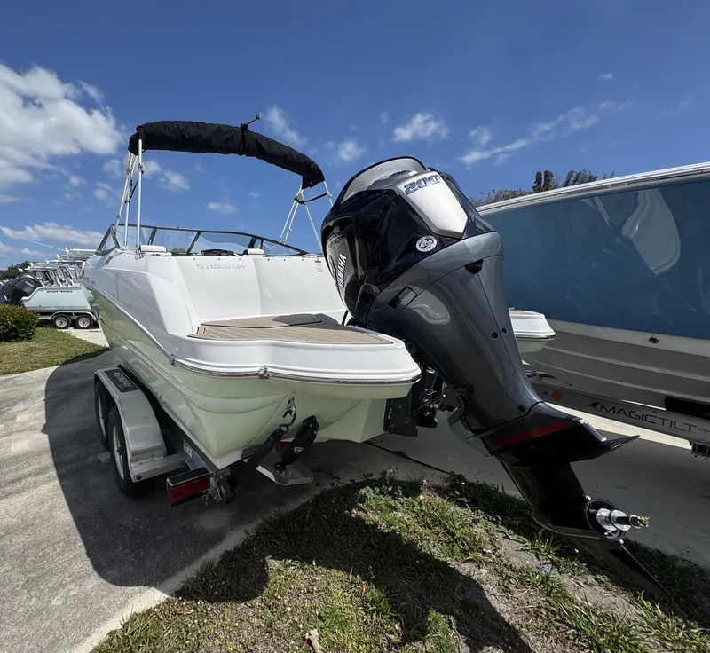 Slide: The Image of 2025 Stingray 231DC boat on trailer with outboard motor, under clear blue sky. - 3