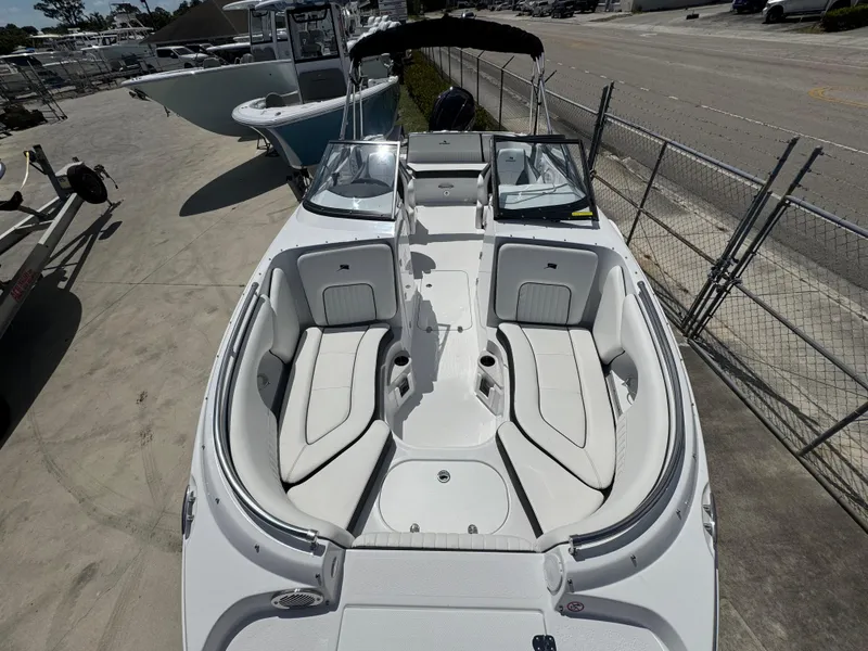 Slide: The Image of 2025 Stingray 231DC boat with spacious seating and sleek design, docked outdoors. - 6