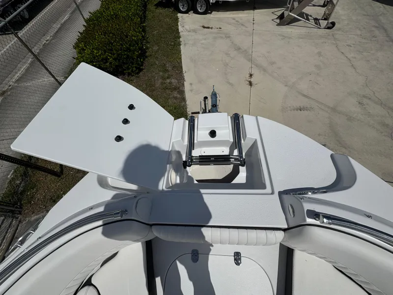Slide: The Image of 2025 Stingray 231DC boat deck with open storage compartment and seating area. - 7