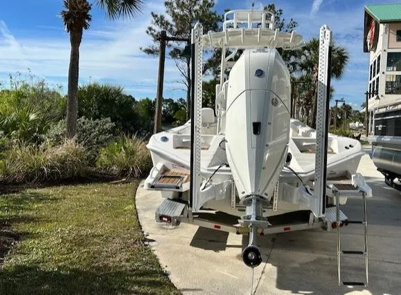Slide: The Image of 2024 Ranger 2660 Bay boat on trailer, parked outdoors near palm trees. - 3