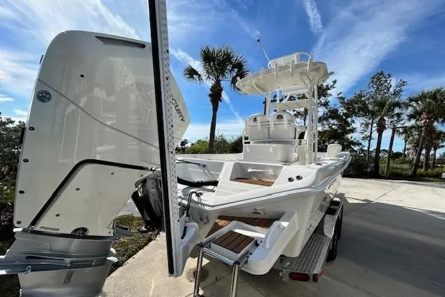 Slide: The Image of 2024 Ranger 2660 Bay boat with outboard motor, parked on a sunny day. - 4