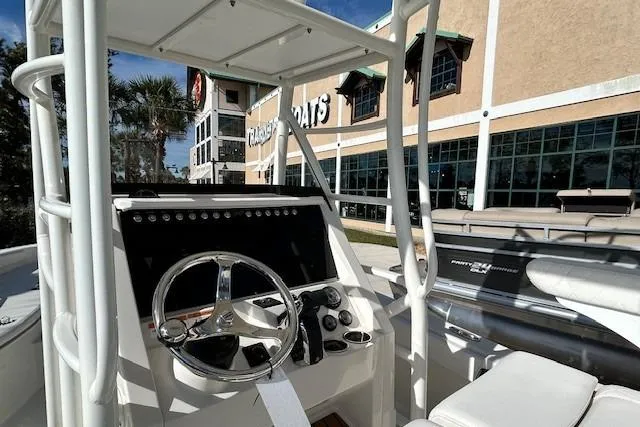 Slide: The Image of 2024 Ranger 2660 Bay boat interior with steering wheel and controls, displayed outdoors. - 5