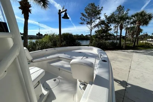 Slide: The Image of 2024 Ranger 2660 Bay boat docked, surrounded by palm trees and a clear blue sky. - 6