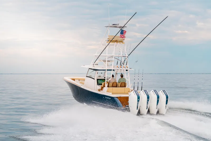 Slide: The Image of Phenom 43 boat cruising on open water, 2025 model, with multiple outboard engines. - 1