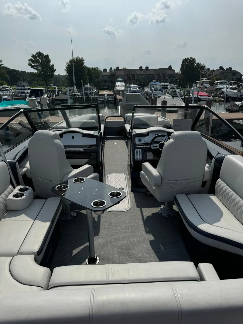 Slide: The Image of 2018 Crest Continental 270 NX-CS Twin boat interior with seating and table, docked at marina. - 14