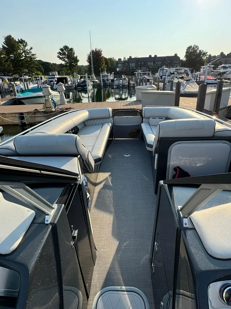 Slide: The Image of 2018 Crest Continental 270 NX-CS Twin boat interior at marina, featuring spacious seating. - 20