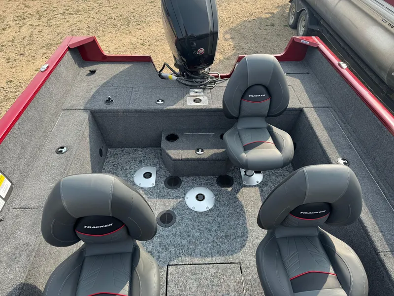 Slide: The Image of 2025 Tracker Pro Guide V-175 WT boat interior with four gray seats and motor. - 8