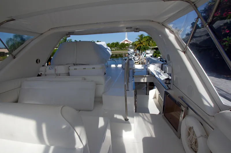 Slide: The Image of Luxurious 1999 Johnson 70 Motor Yacht interior with sleek white seating and modern amenities. - 10