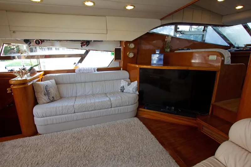 Slide: The Image of Interior of 1999 Johnson 70 Motor Yacht with cozy seating and modern entertainment system. - 18