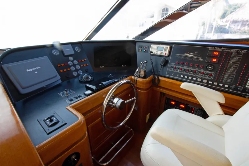 Slide: The Image of Cockpit of 1999 Johnson 70 Motor Yacht with steering wheel and control panels. - 22