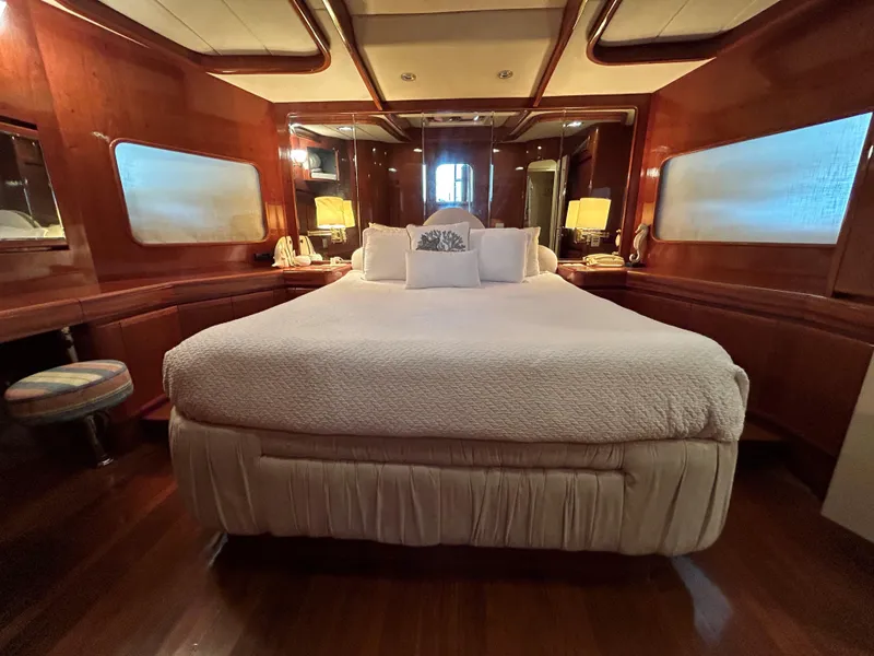 Slide: The Image of Luxurious bedroom in 1999 Johnson 70 Motor Yacht with elegant wood paneling and plush bedding. - 27