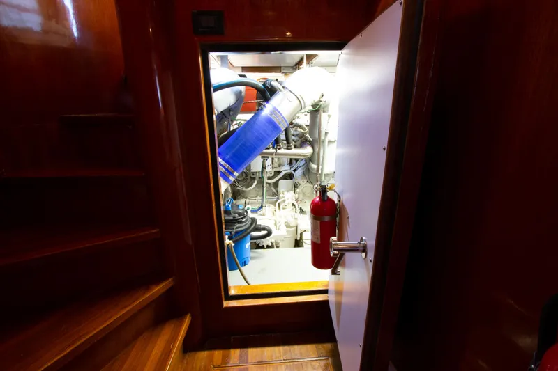 Slide: The Image of Engine room of a 1999 Johnson 70 Motor Yacht with visible equipment and fire extinguisher. - 31