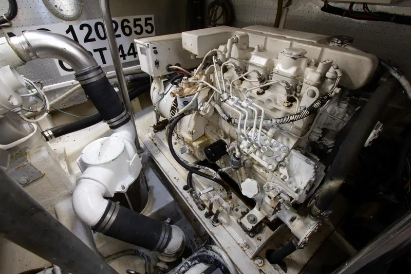 Slide: The Image of Engine room of 1999 Johnson 70 Motor Yacht, showcasing mechanical components and piping. - 34
