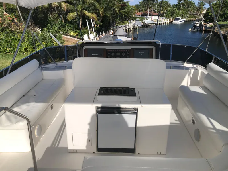 Slide: The Image of 1999 Johnson 70 Motor Yacht deck with seating and waterway view. - 8