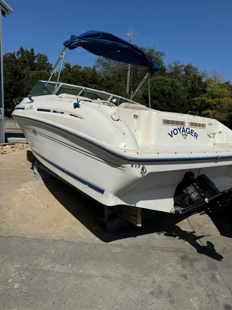 Slide: The Image of 1996 Sea Ray 215 Express Cruiser boat with blue canopy on dry dock. - 10