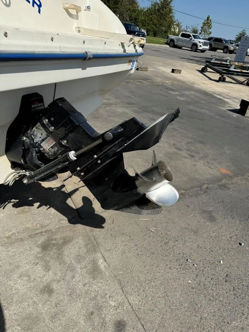 Slide: The Image of 1996 Sea Ray 215 Express Cruiser boat with visible outboard motor in a parking area. - 11