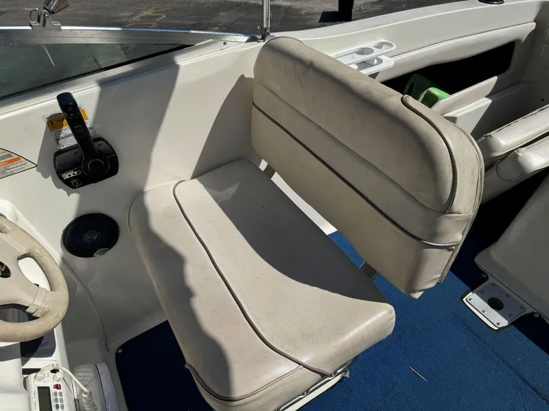 Slide: The Image of 1996 Sea Ray 215 Express Cruiser interior with beige seating and blue carpet. - 19