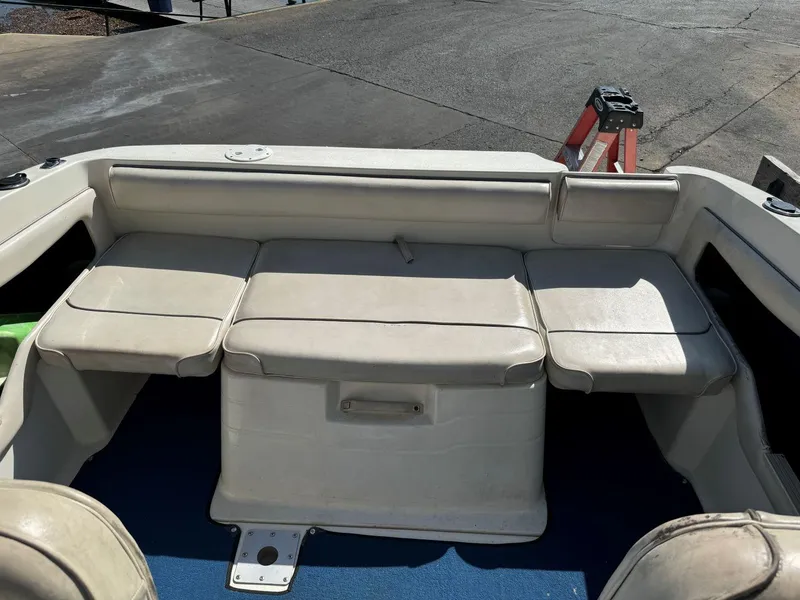 Slide: The Image of 1996 Sea Ray 215 Express Cruiser interior seating area with white upholstery. - 21