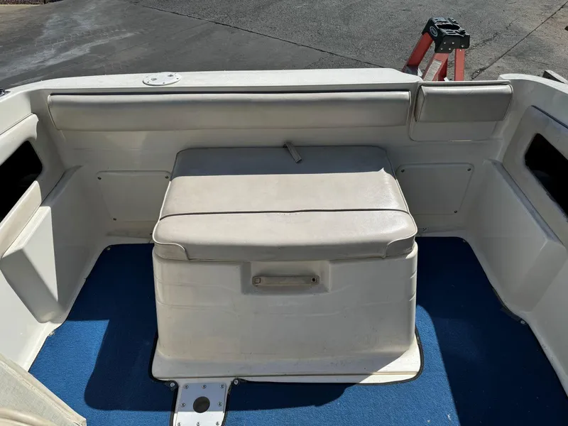 Slide: The Image of 1996 Sea Ray 215 Express Cruiser interior seating with blue carpet. - 22